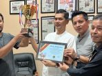 Atlet berkuda asal Aceh, Azman Munte perlihatkan piala kejuaraan pacuan kuda Piala Menteri Pertahanan, Senin 27 Juni 2022. (BASAJAN.NET/ISTIMEWA)