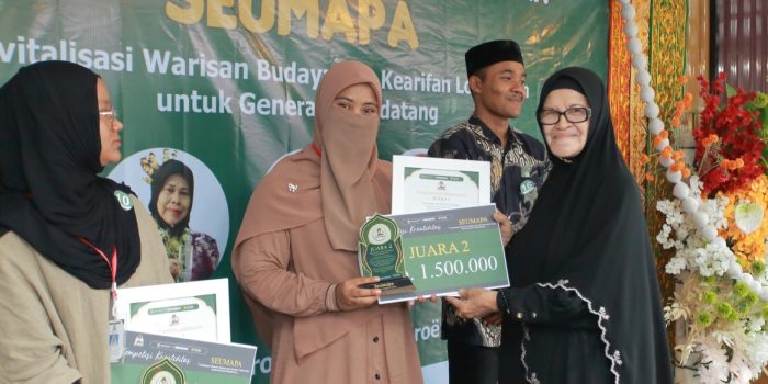 Putri Misinaldila menerima hadiah juara 2 Kompetisi Seumapa yang diserahkan oleh Penyair Wanita Aceh, Rosni Idham, Ahad 17 Mei 2026. (BASAJAN.NETHARIS MUNAWAR)